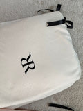 Bolsa de jacquard marfil con monograma RR y cinta de satín negro, empaque del juego de sábanas Rosas Home